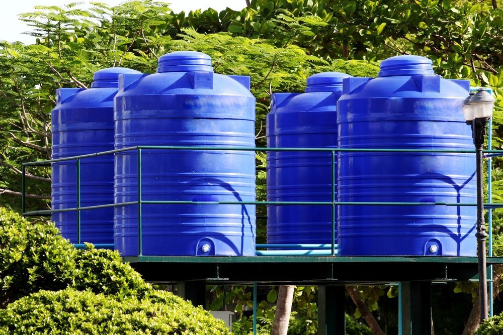 A Row Of Blue Water Tanks Are Sitting On Top Of A Green Platform — Ram Star Plastics In Winnellie, NT