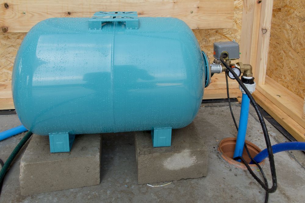 A Blue Water Tank Is Sitting On Top Of A Concrete Block — Ram Star Plastics In Winnellie, NT