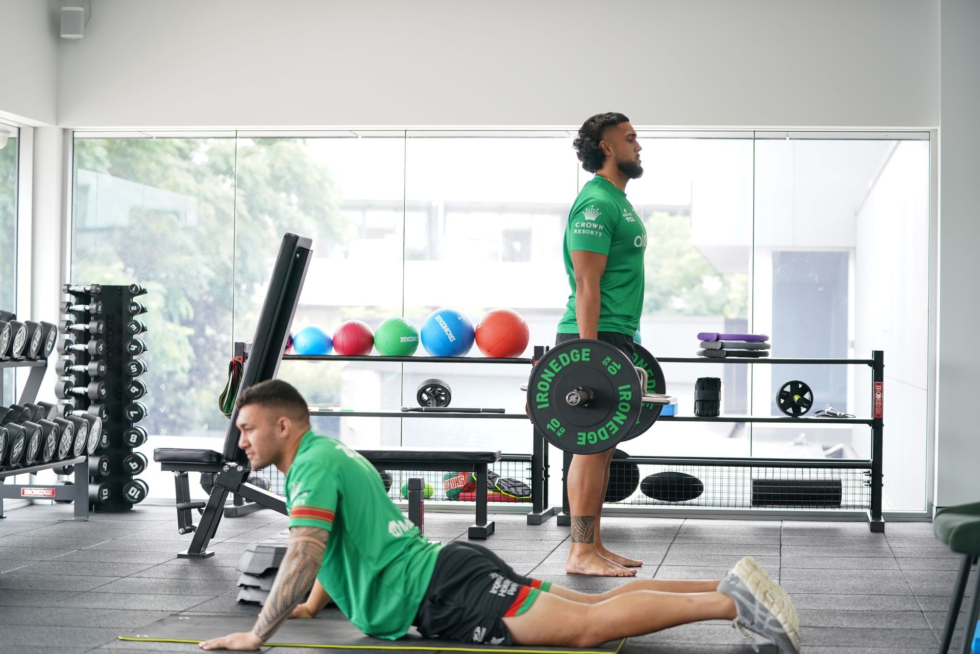 Two men are doing exercises in a gym.