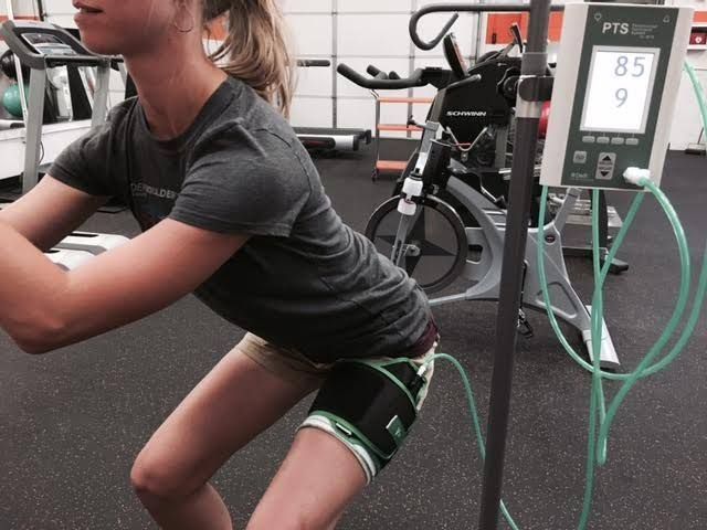 A woman squatting in front of a monitor that says 85 on it