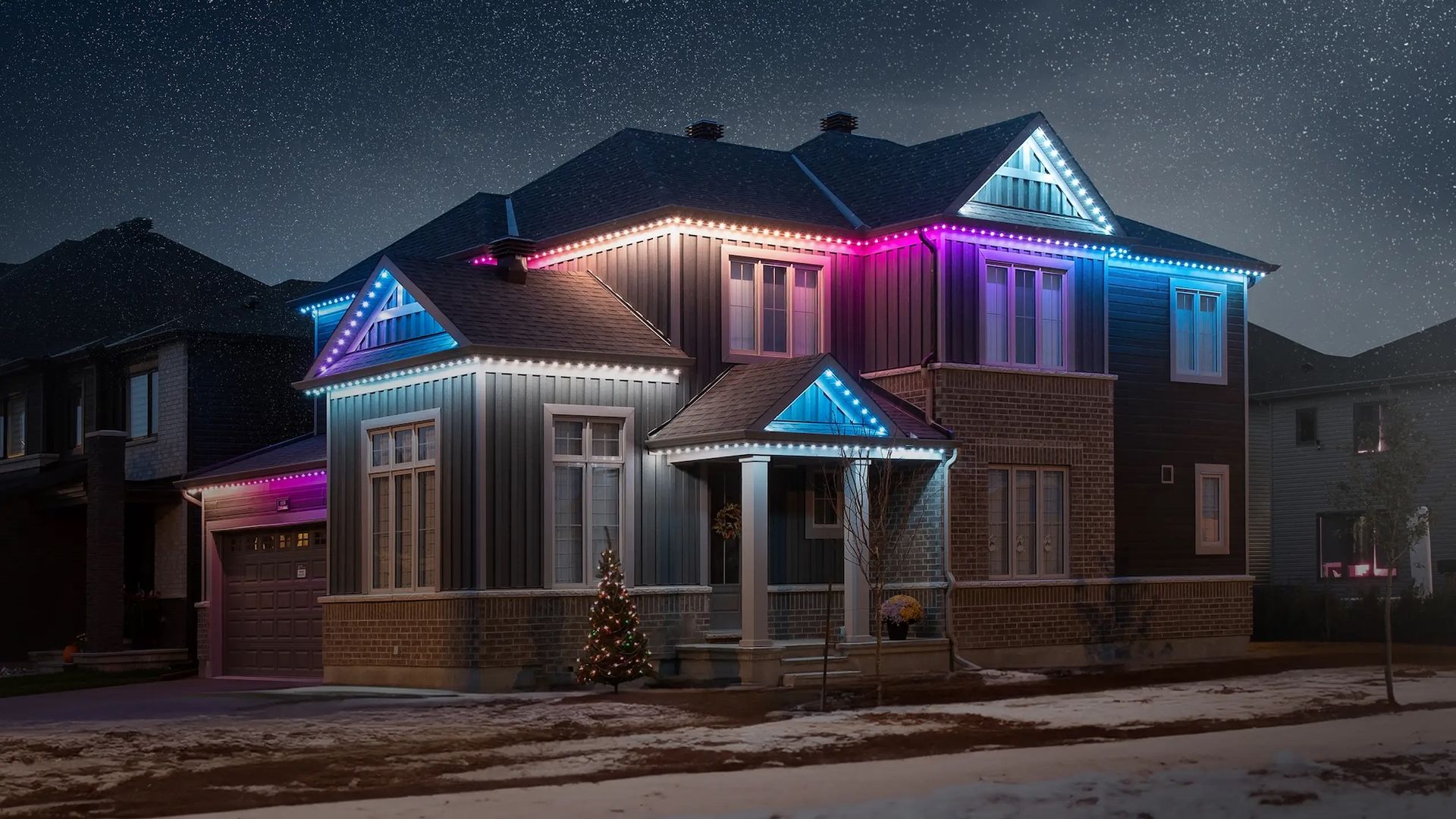 A suburban house at night, decorated with vibrant pink and blue LED holiday lights under a starry, snow-covered sky.