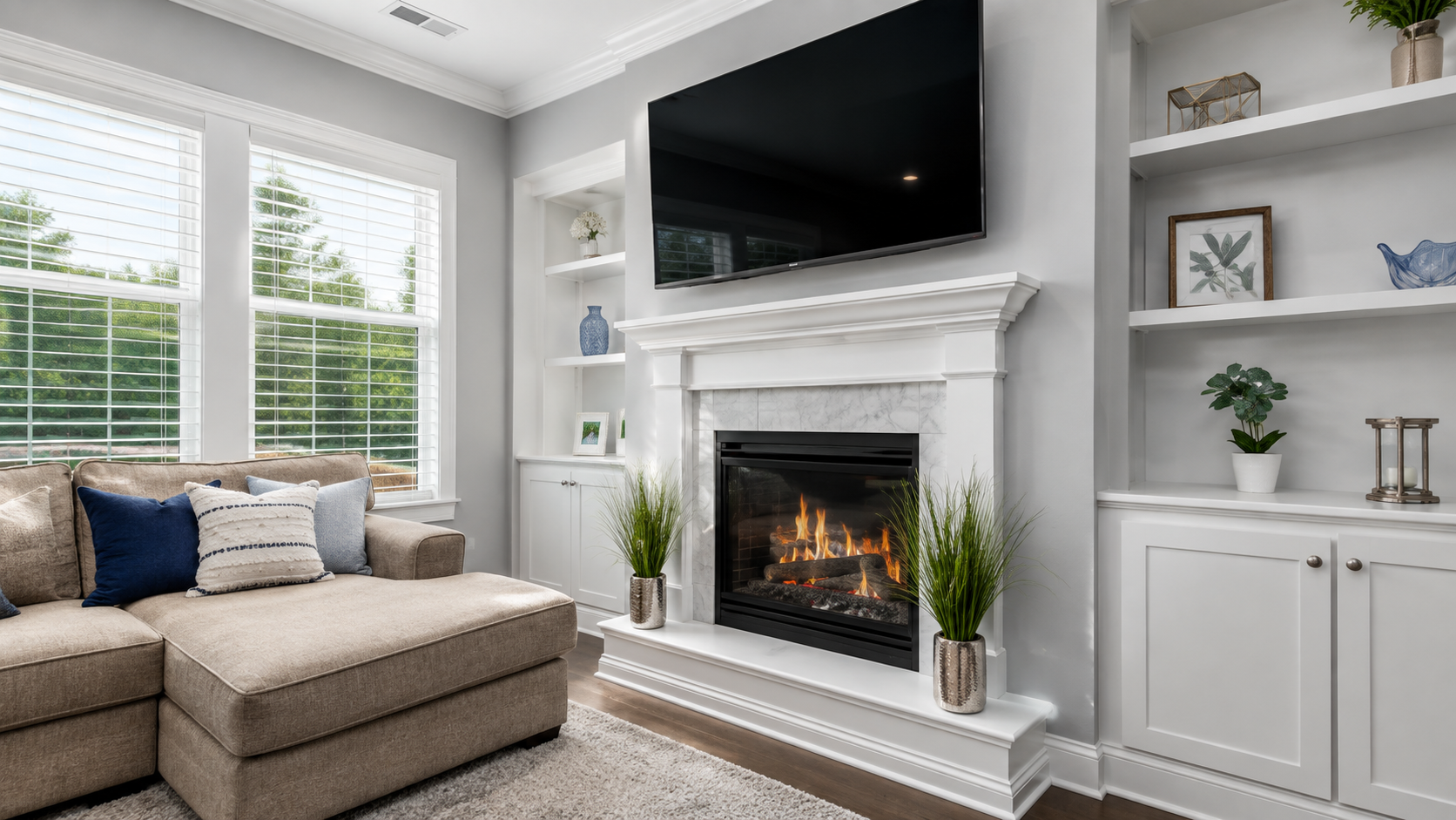 Bright living room with sectional sofa, fireplace, wall-mounted TV, and white built-in cabinets