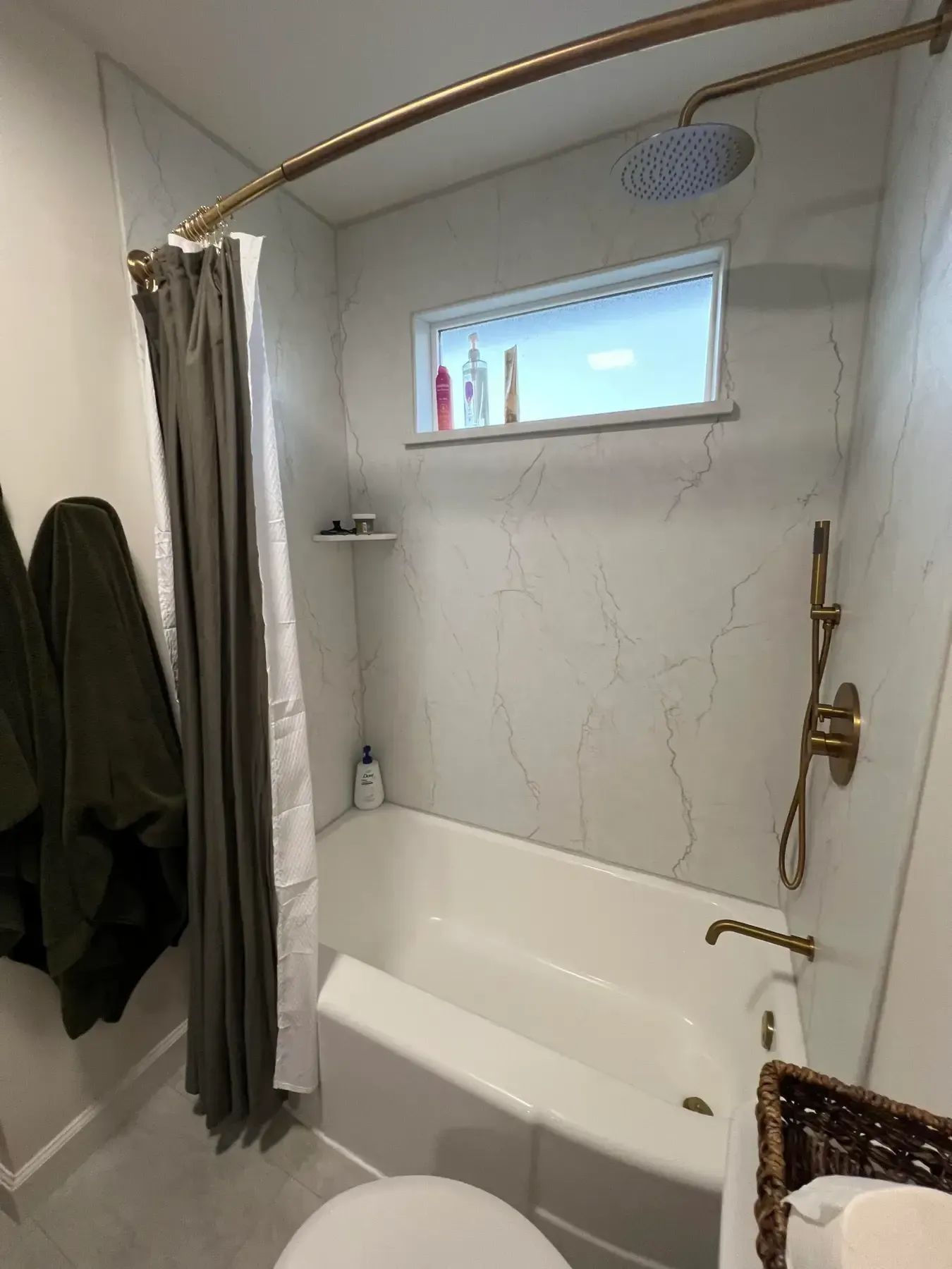 Small bathroom with a shower curtain, bathtub, handheld shower, and small frosted window.