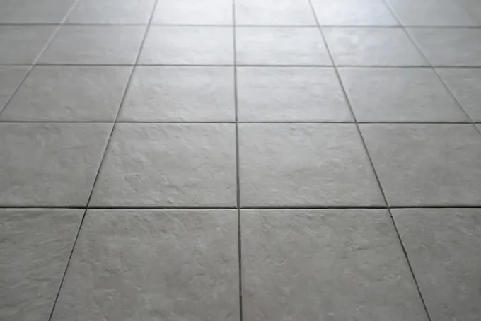 Gray tiled floor with a grid pattern, viewed from above