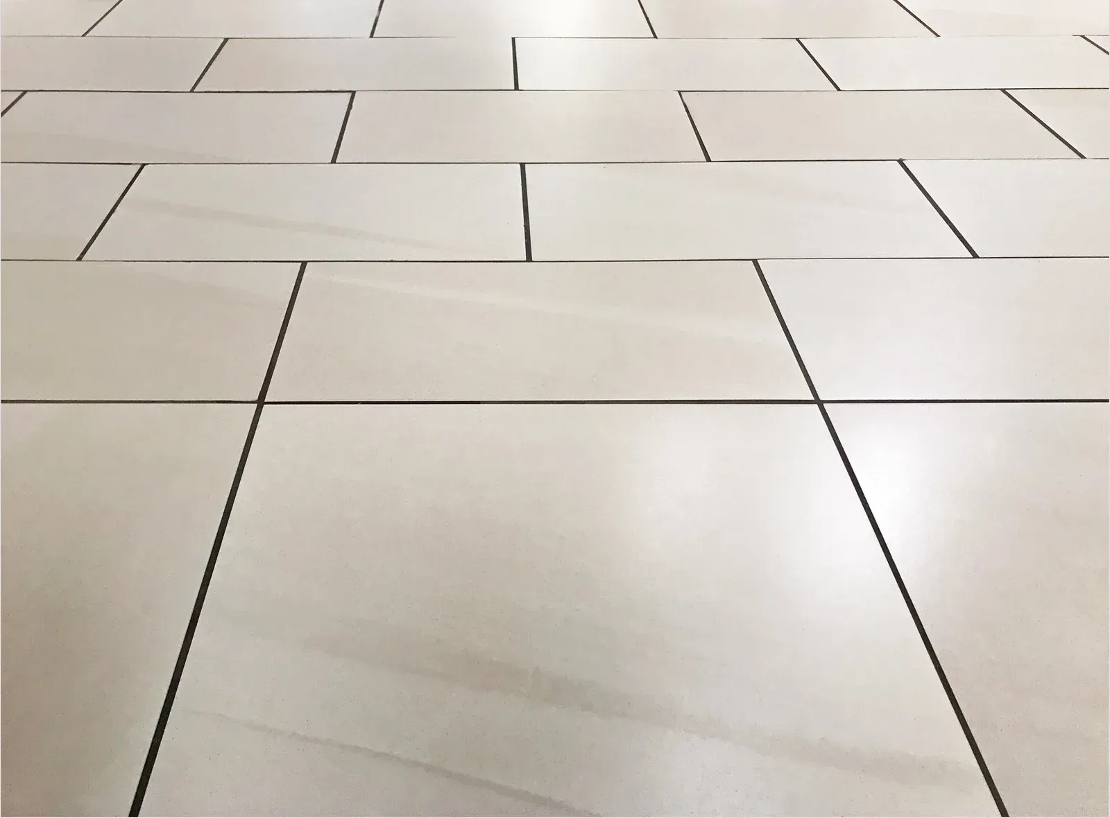 Light-colored tiled floor with dark grout lines forming a geometric pattern