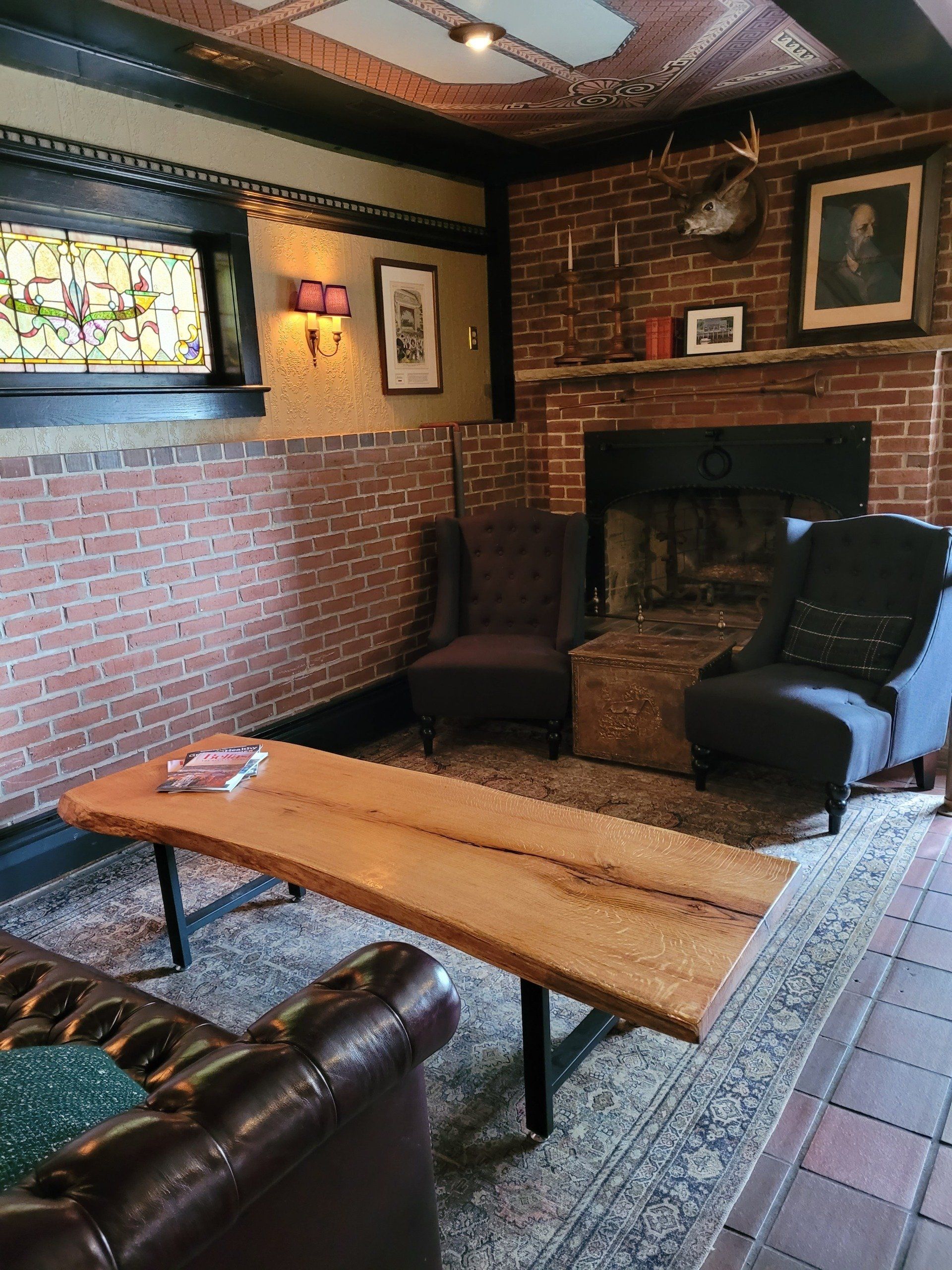 A living room with a table , chairs , and a fireplace.