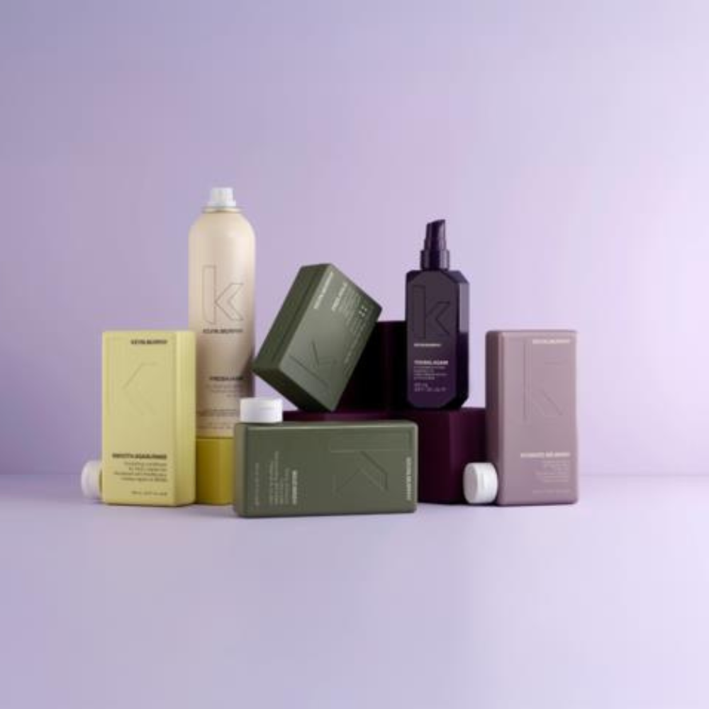 White cosmetic bottles and a tube arranged with stones on a light textured surface.