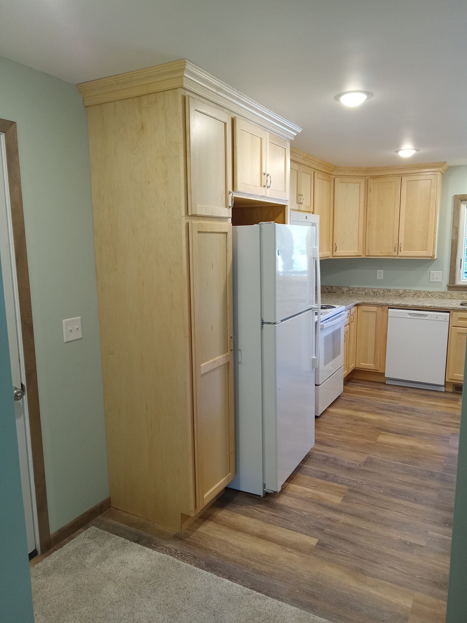 A kitchen with a refrigerator , stove , dishwasher and cabinets.