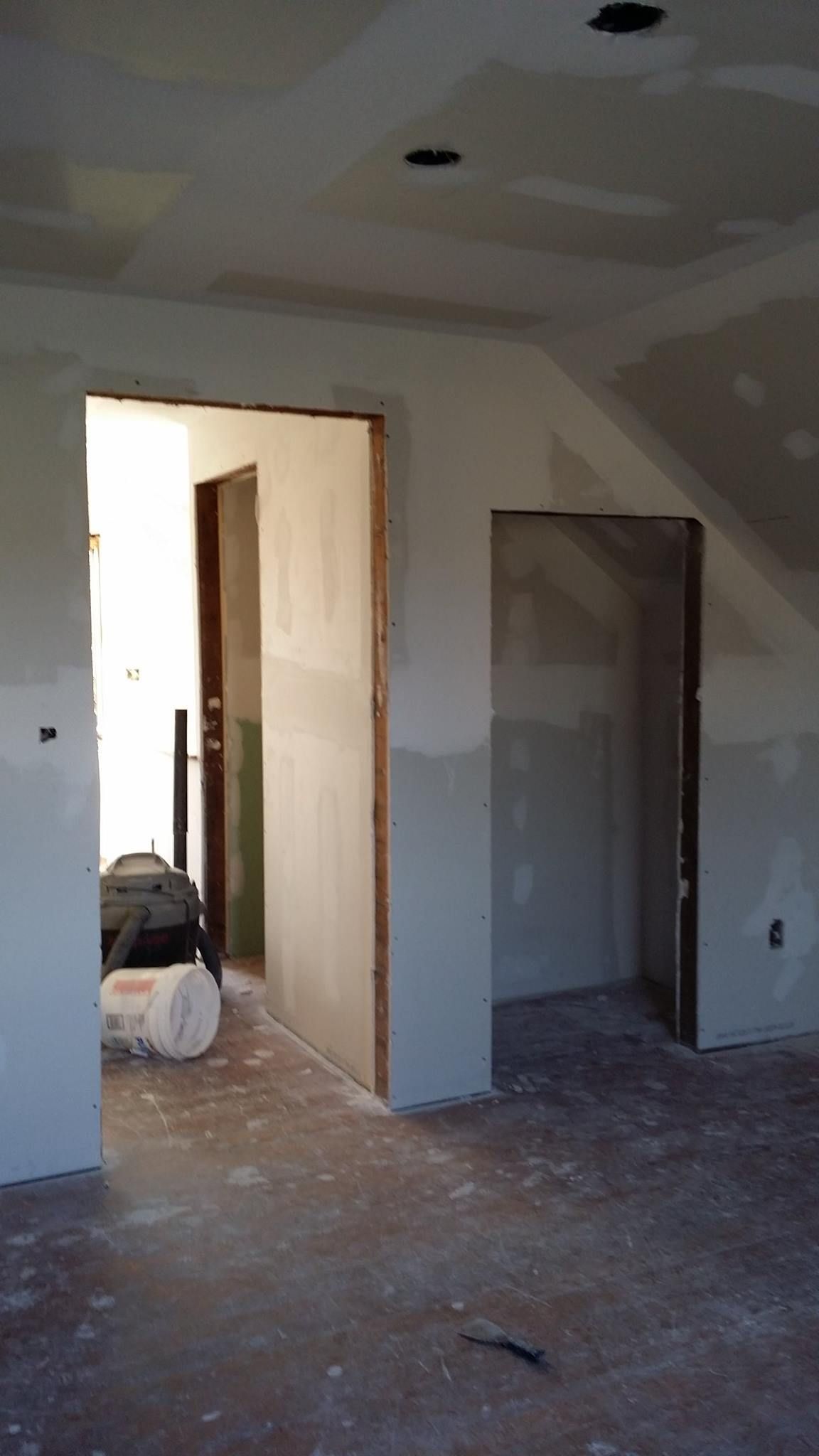 A room that is being remodeled with a roll of insulation on the floor.
