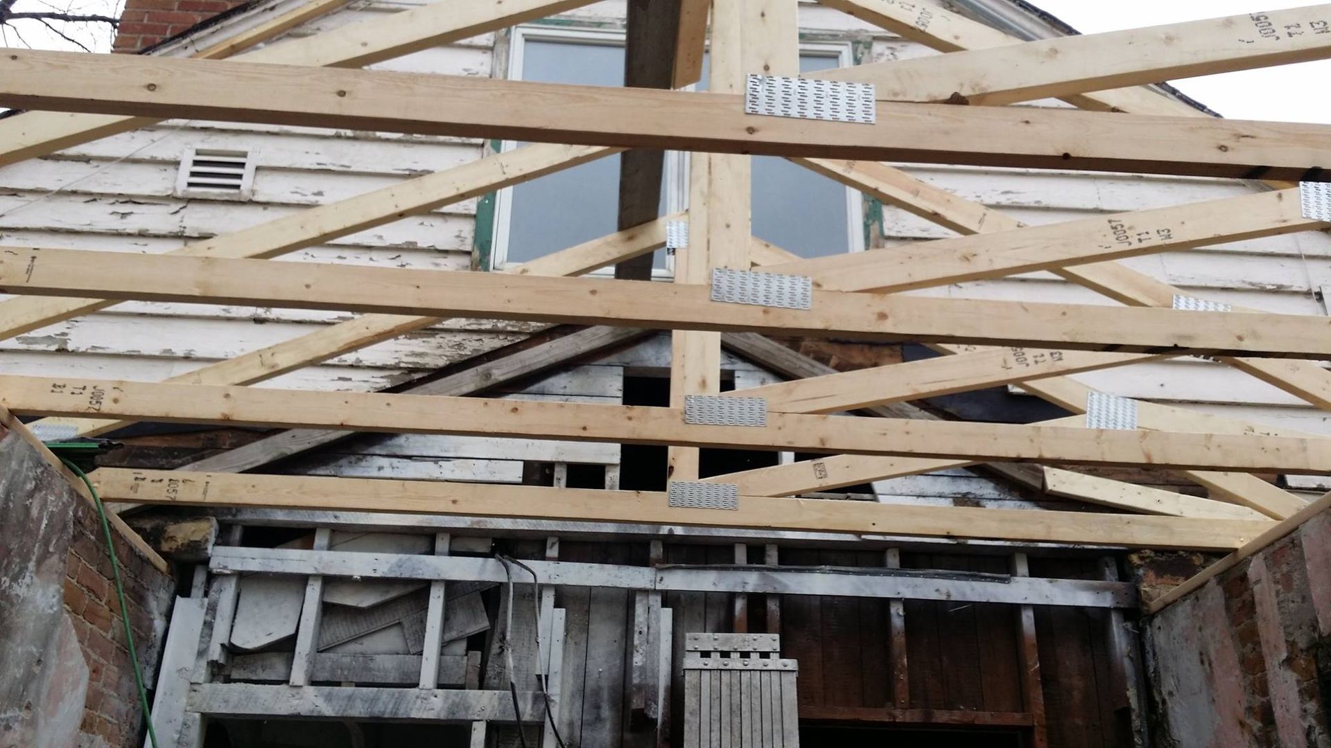 The roof of a house is being built with wooden beams.