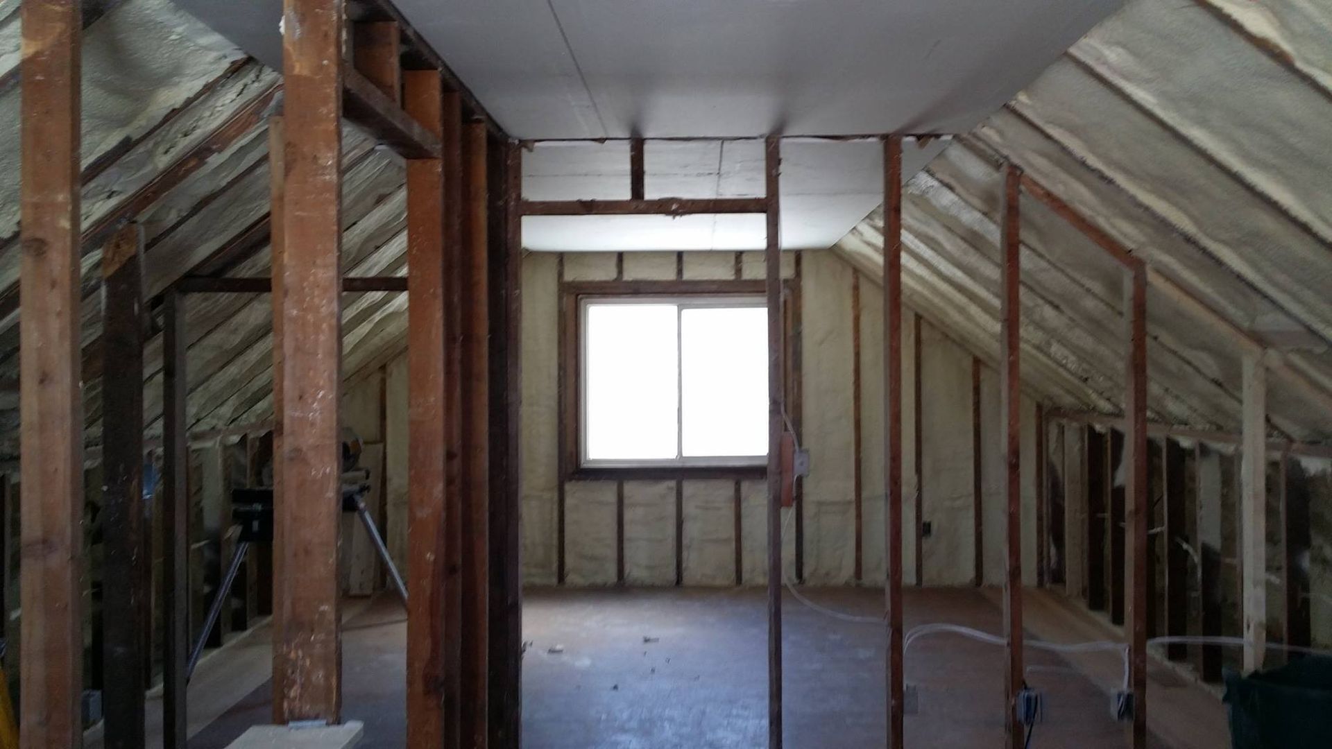 There is a window in the attic of a house being built.