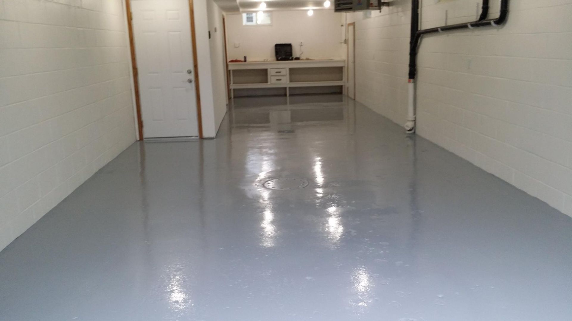 A garage with a gray floor and white walls.