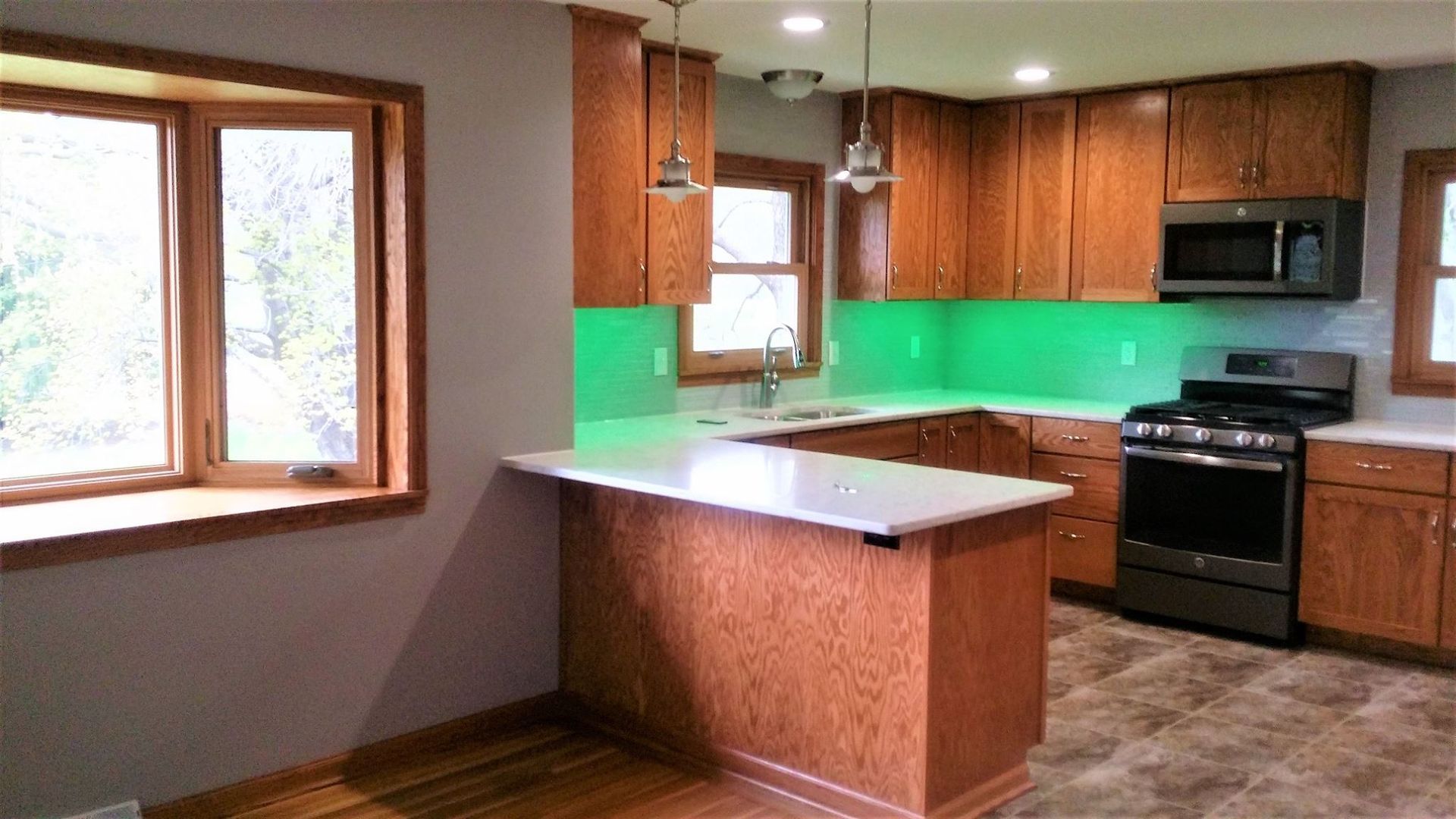 A kitchen with wooden cabinets and a green counter top