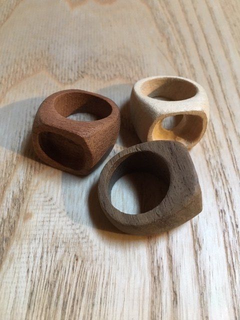 Tre piccoli blocchi di legno a forma di anello su una superficie di legno chiaro