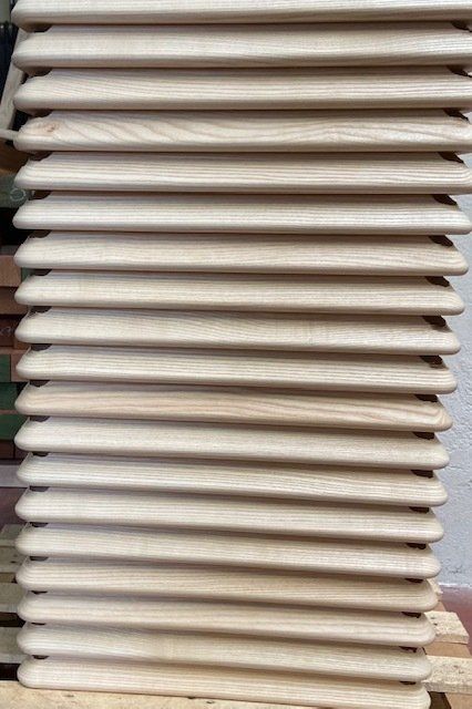 Pila di sedie o tavoli pieghevoli beige riposti verticalmente all'interno
