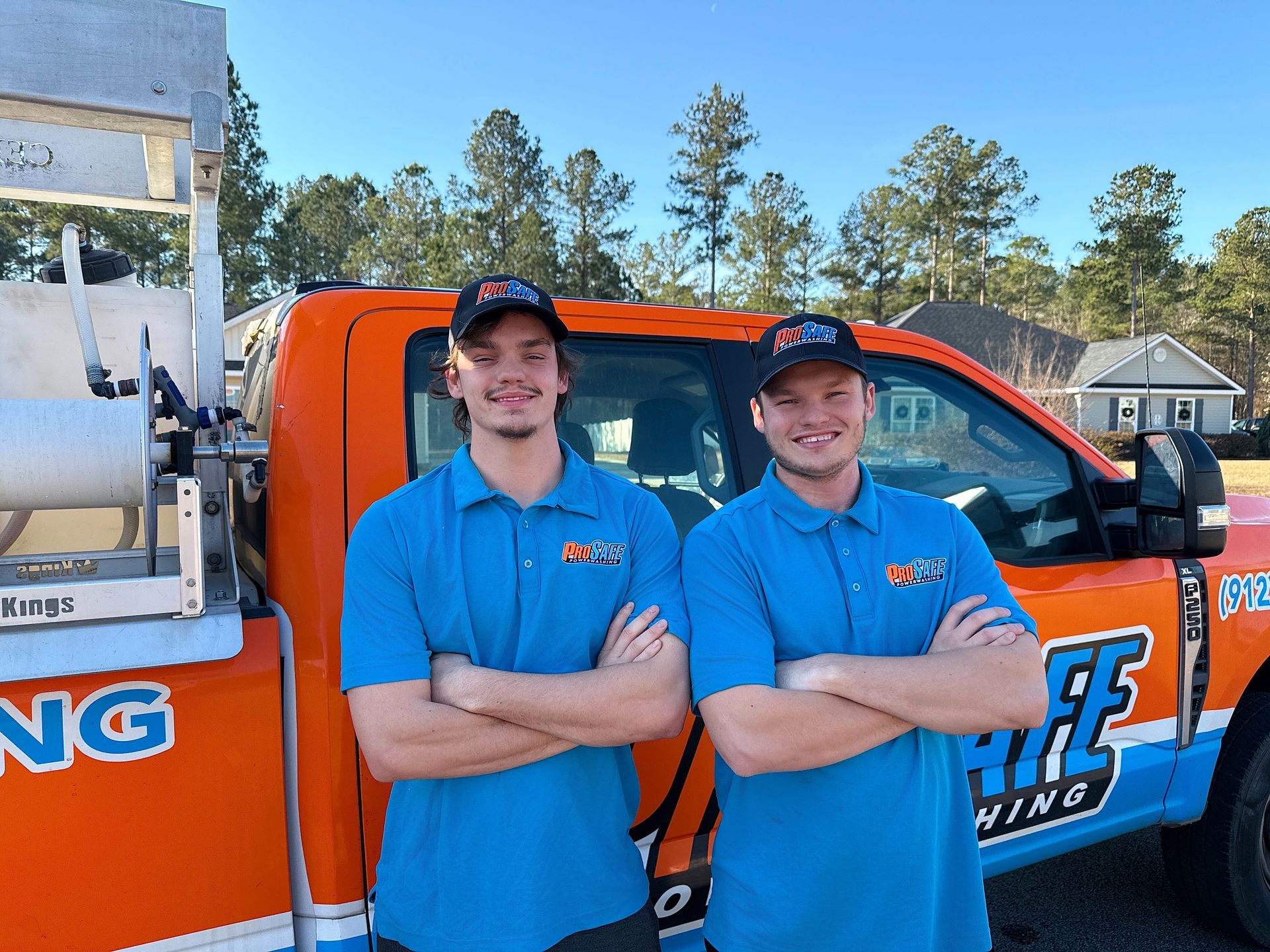 A man and a woman are standing next to each other holding a hose.