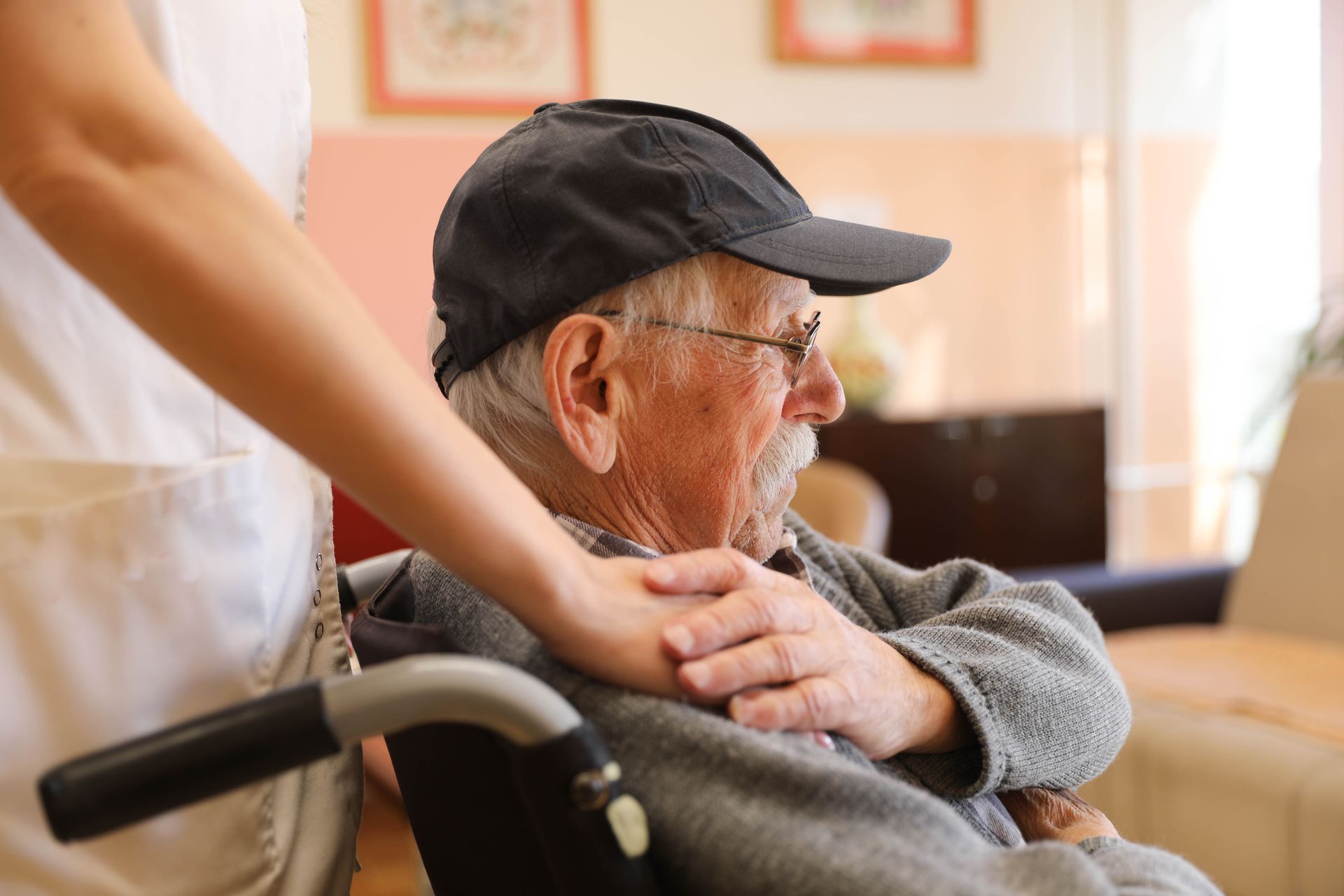 Elderly man in wheelchair, being assisted by a healthcare worker indoors. Elderly man in wheelchair, being assisted by a healthcare worker indoors.