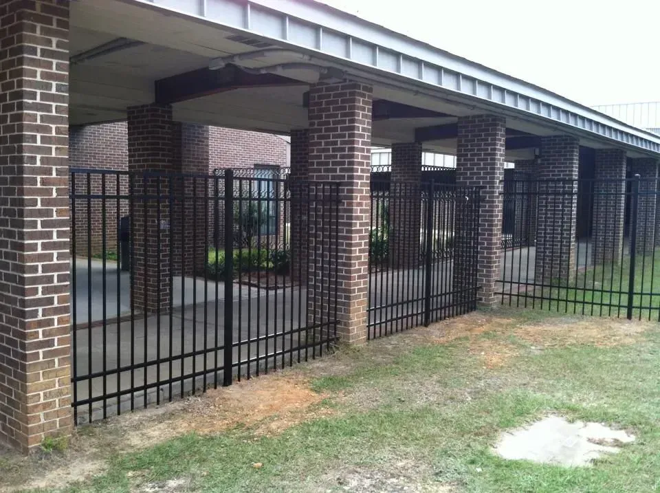 A brick building with a metal fence in front of it