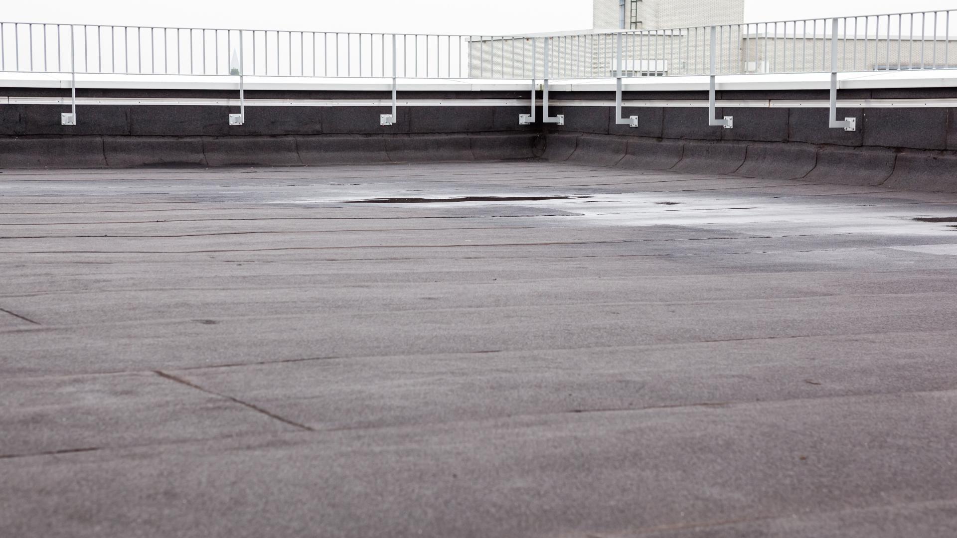 An empty rooftop with a fence in the background