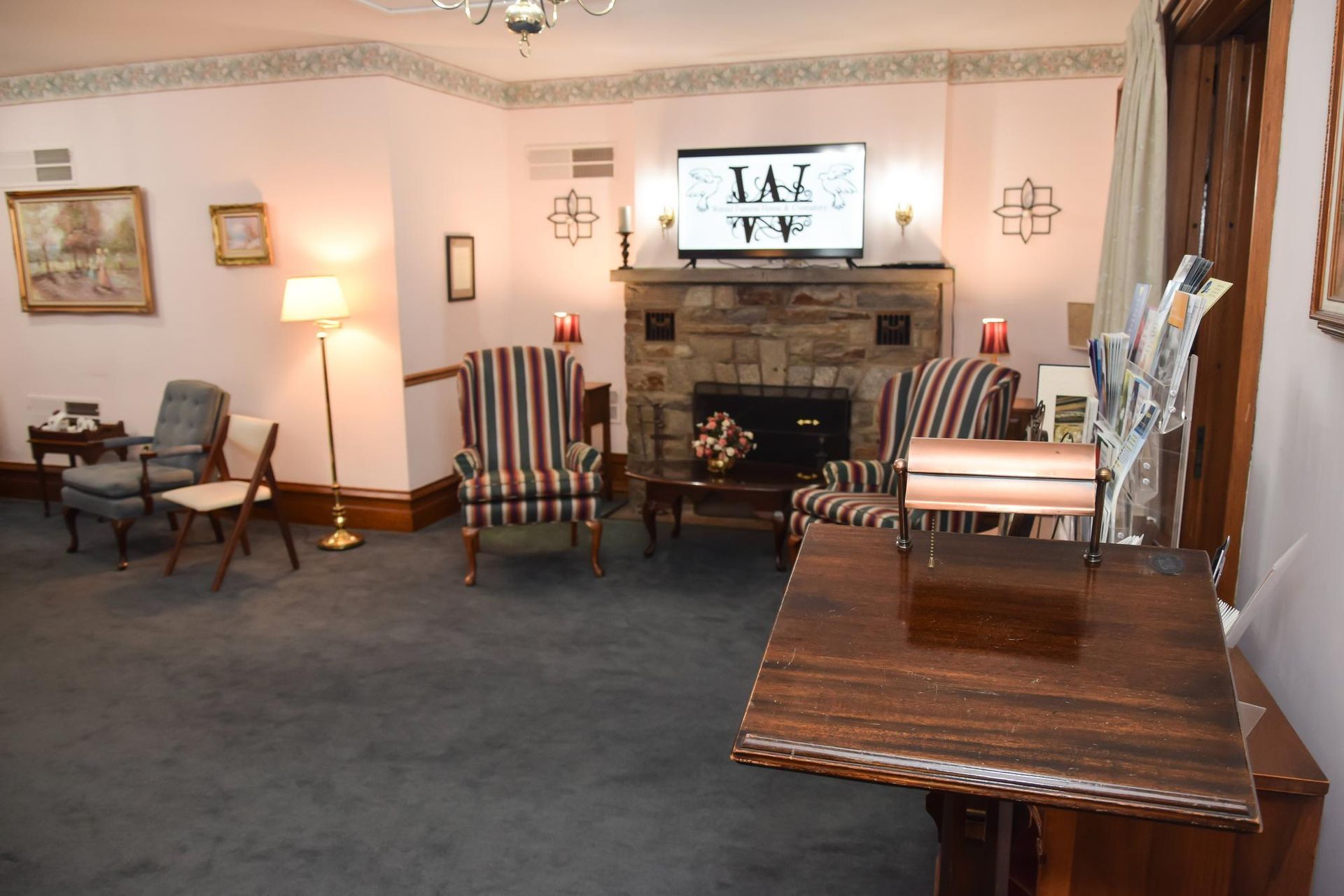Living room with chairs, fireplace, TV, and wooden table in a cozy seating area