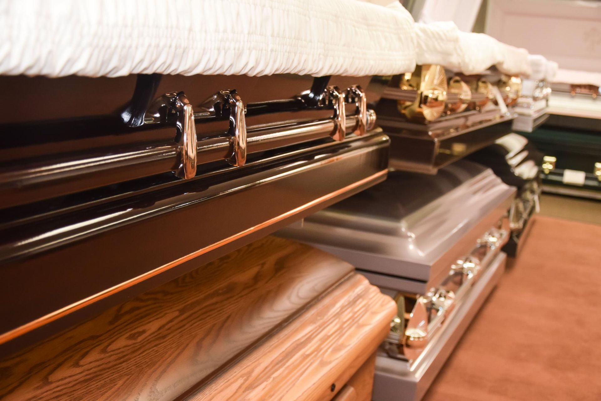 Open casket funeral display with white floral lining and a wood-paneled interior