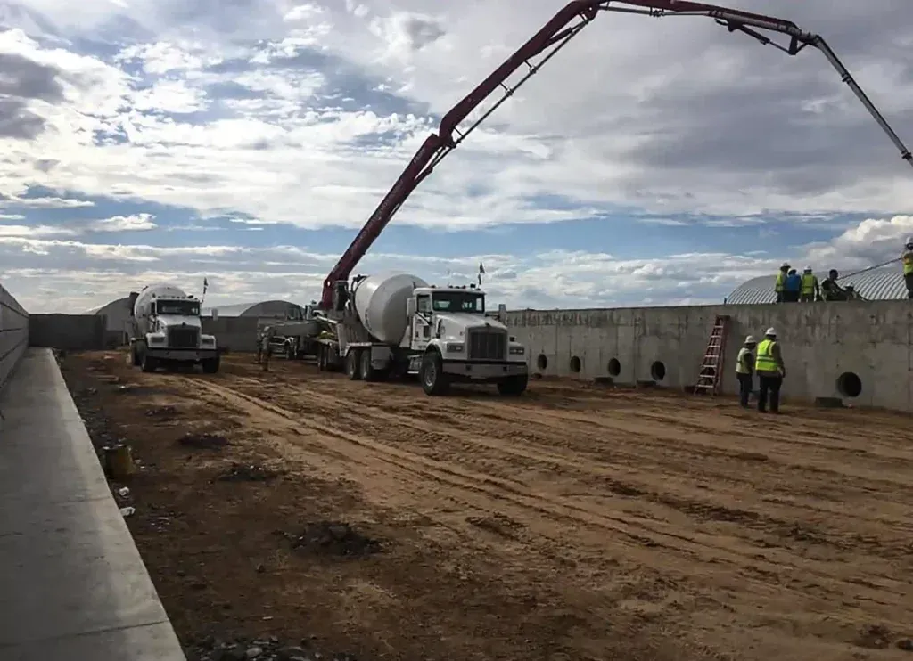A concrete pump is being used to pour concrete on a construction site.