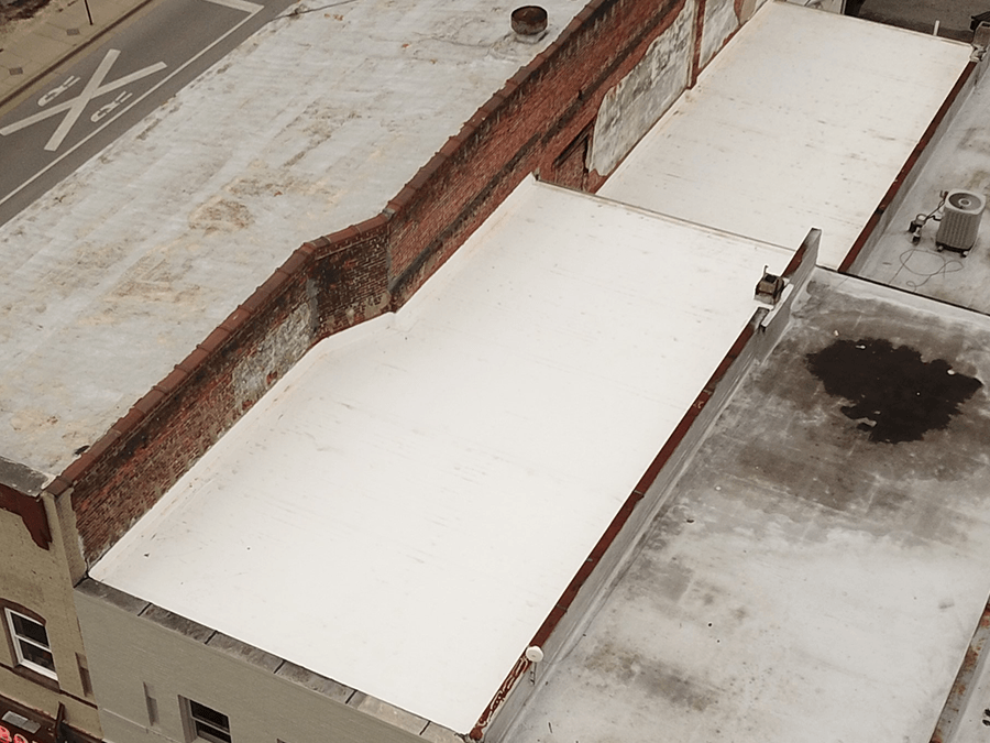 An aerial view of a building with a white roof