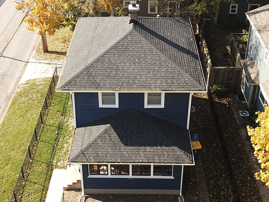 An aerial view of a blue house with a gray roof