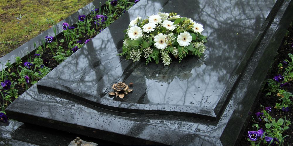 Funeral grave with white flower arrangement at cemetery representing Funeral Home and Cremations in Annetta, TX