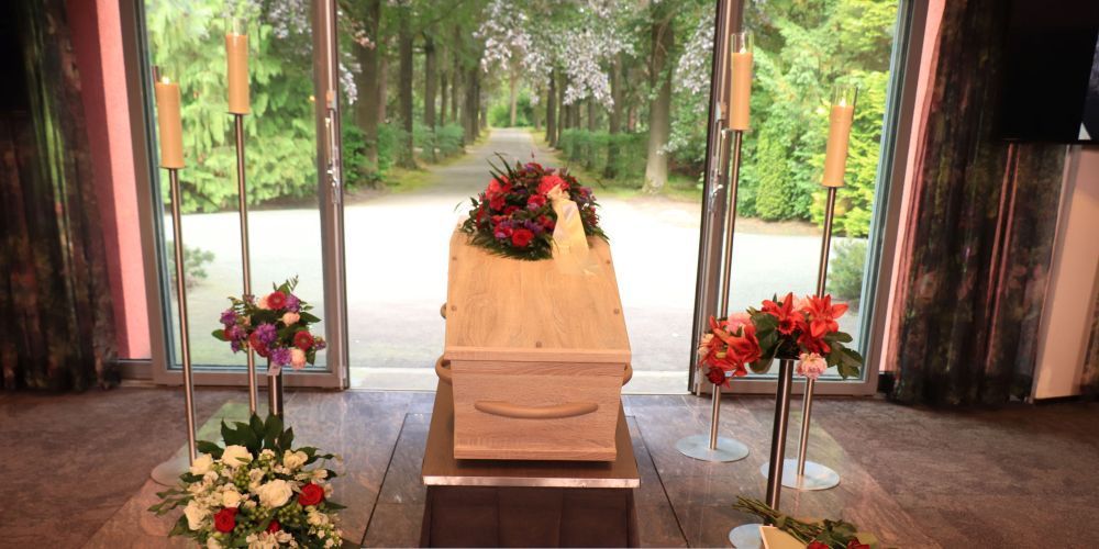 Memorial service setup with casket, candles, and flower stands inside a chapel at a funeral home and cremations provider in Weatherford, TX
