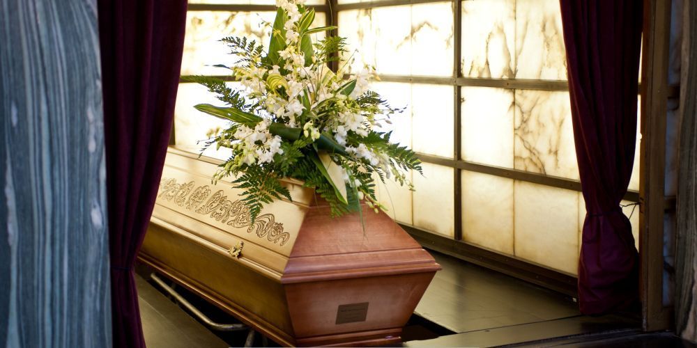 Polished wooden casket with floral arrangement during a memorial service at a funeral home and cremations in Aledo, TX
