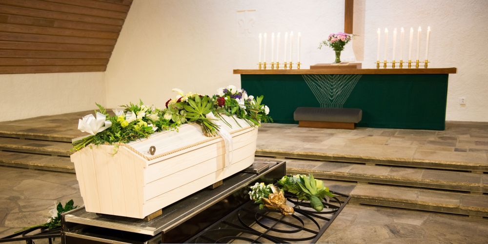 Casket with floral arrangements displayed inside a chapel during a ceremony at a funeral home and cremations in Aledo, TX