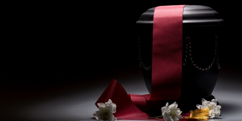 Memorial cremation urn with ribbon and flowers representing services from a funeral home and cremations in Willow Park, TX