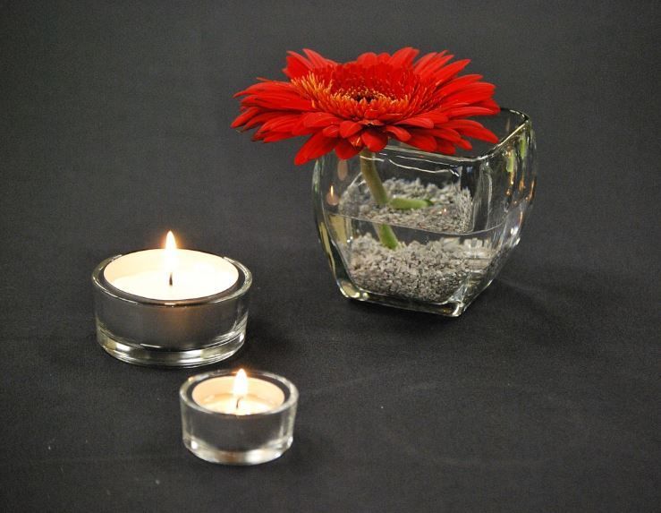 Candlelight and red gerbera centerpiece for calm planning, cremation services Annetta, TX tips