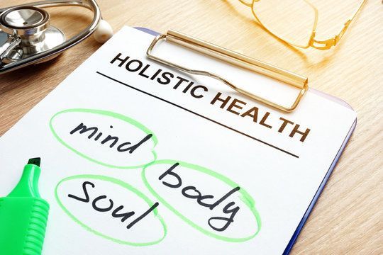 A clipboard with the words holistic health written on it