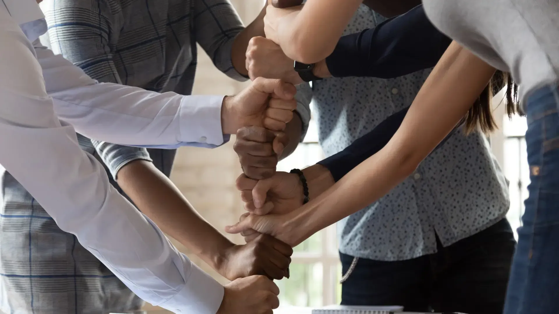 A group of people are putting their hands together.