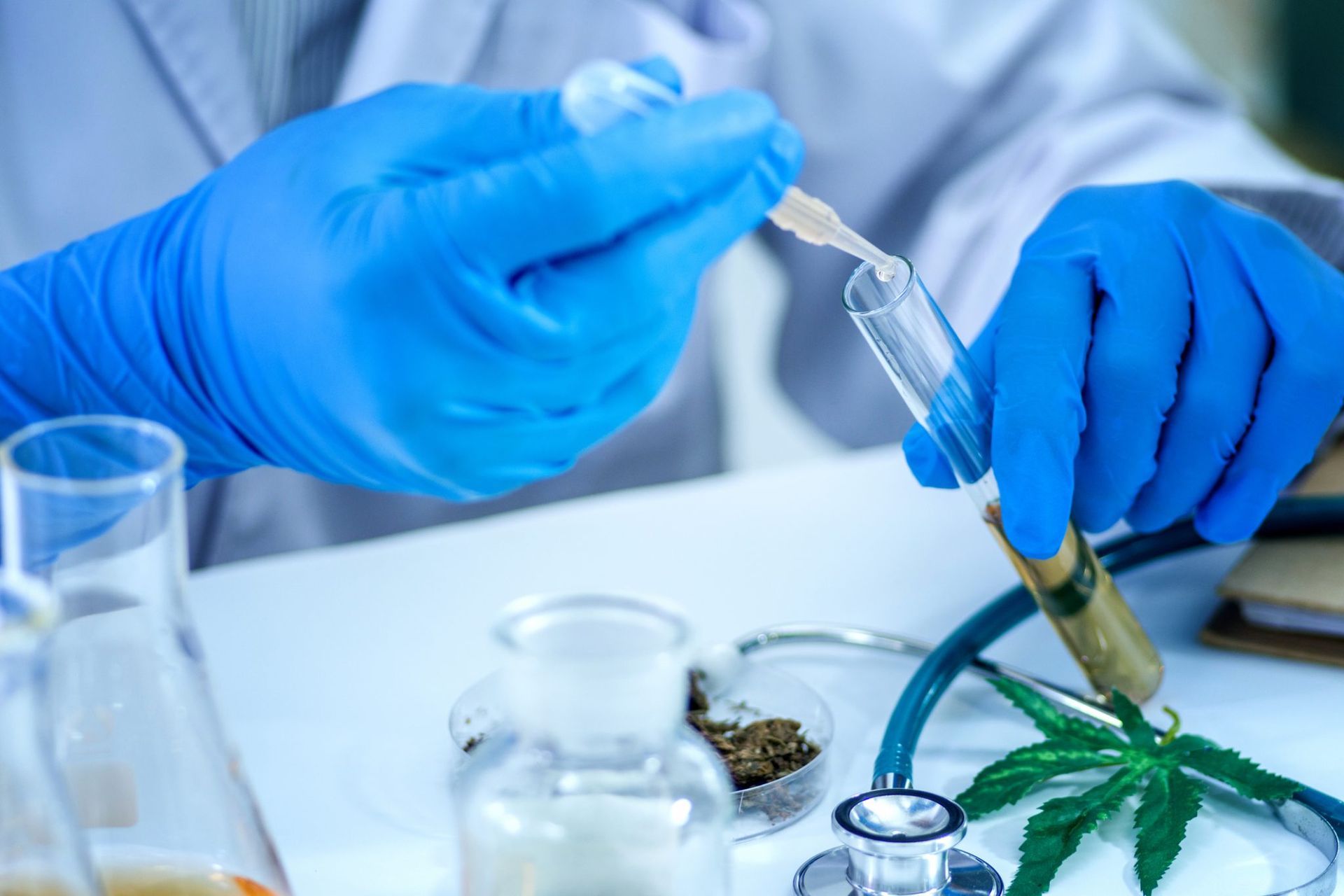A scientist is holding a pipette and pouring liquid into a test tube.