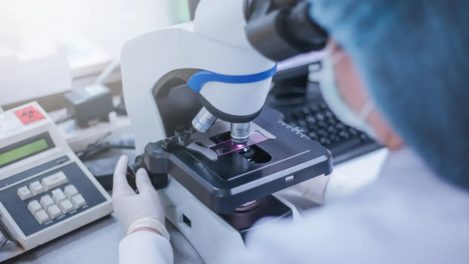 A scientist is looking through a microscope in a laboratory.
