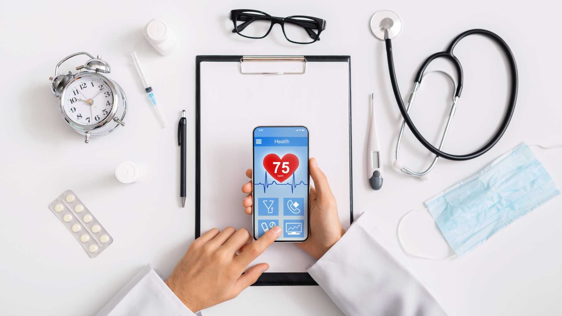 A doctor is holding a cell phone with a heart on it.