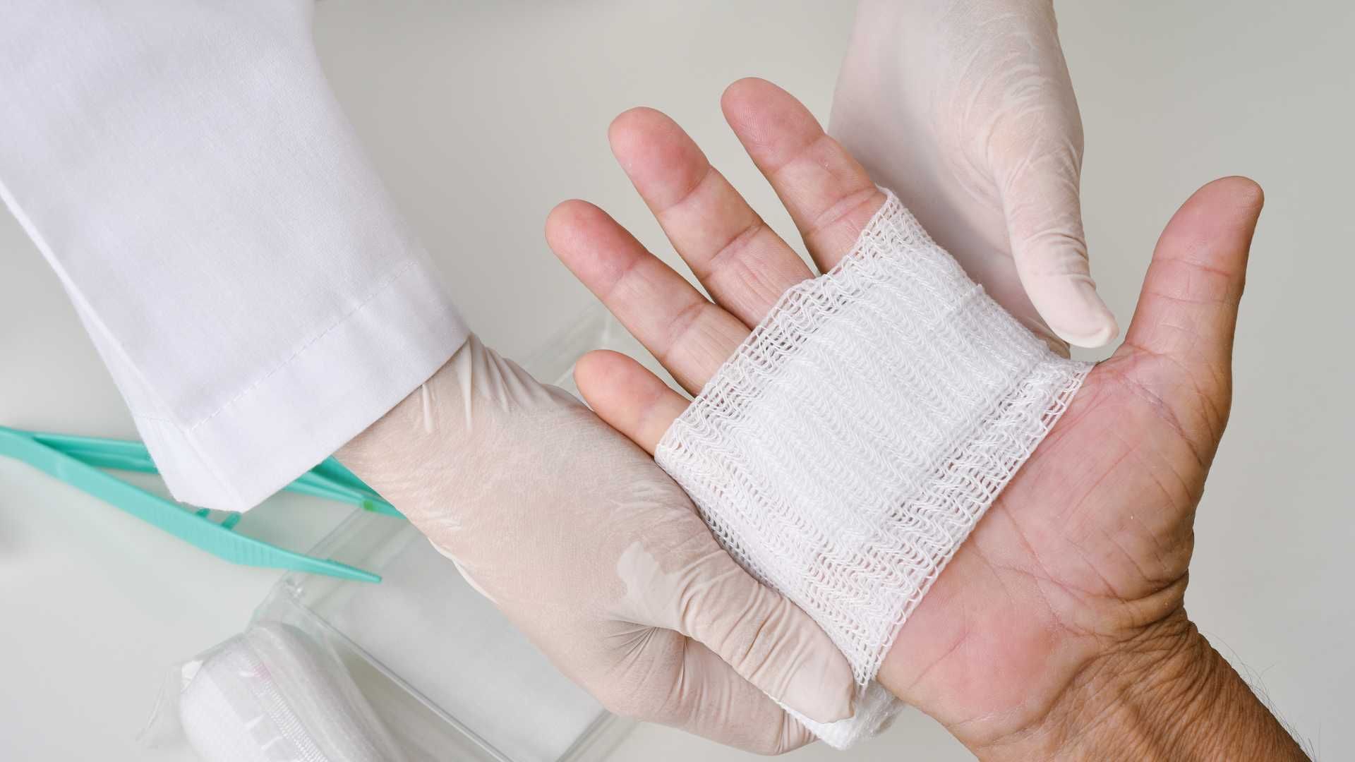 A person is getting a bandage on their hand.