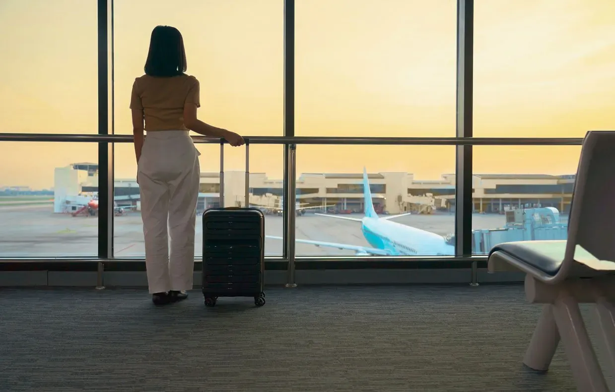 tourist standing with luggage watching sunset