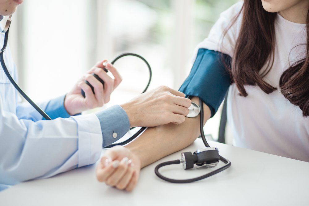 doctor using sphygmomanometer with stethoscope
