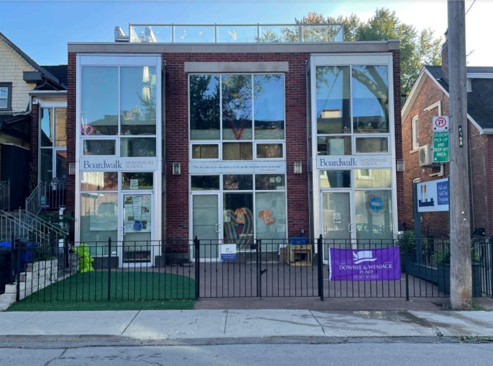 Brick building with large windows; a business with sign: 
