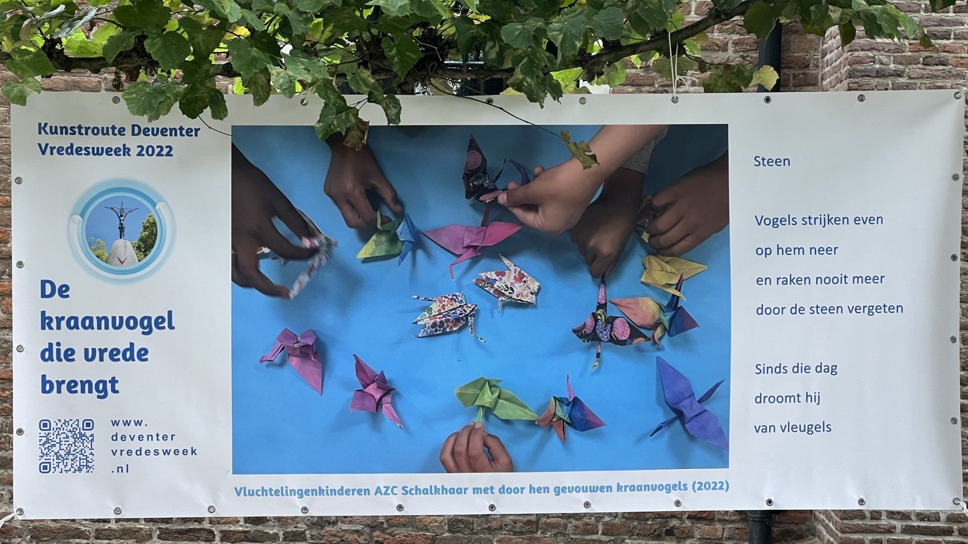 Banner featuring colorful paper cranes on a blue background and the text