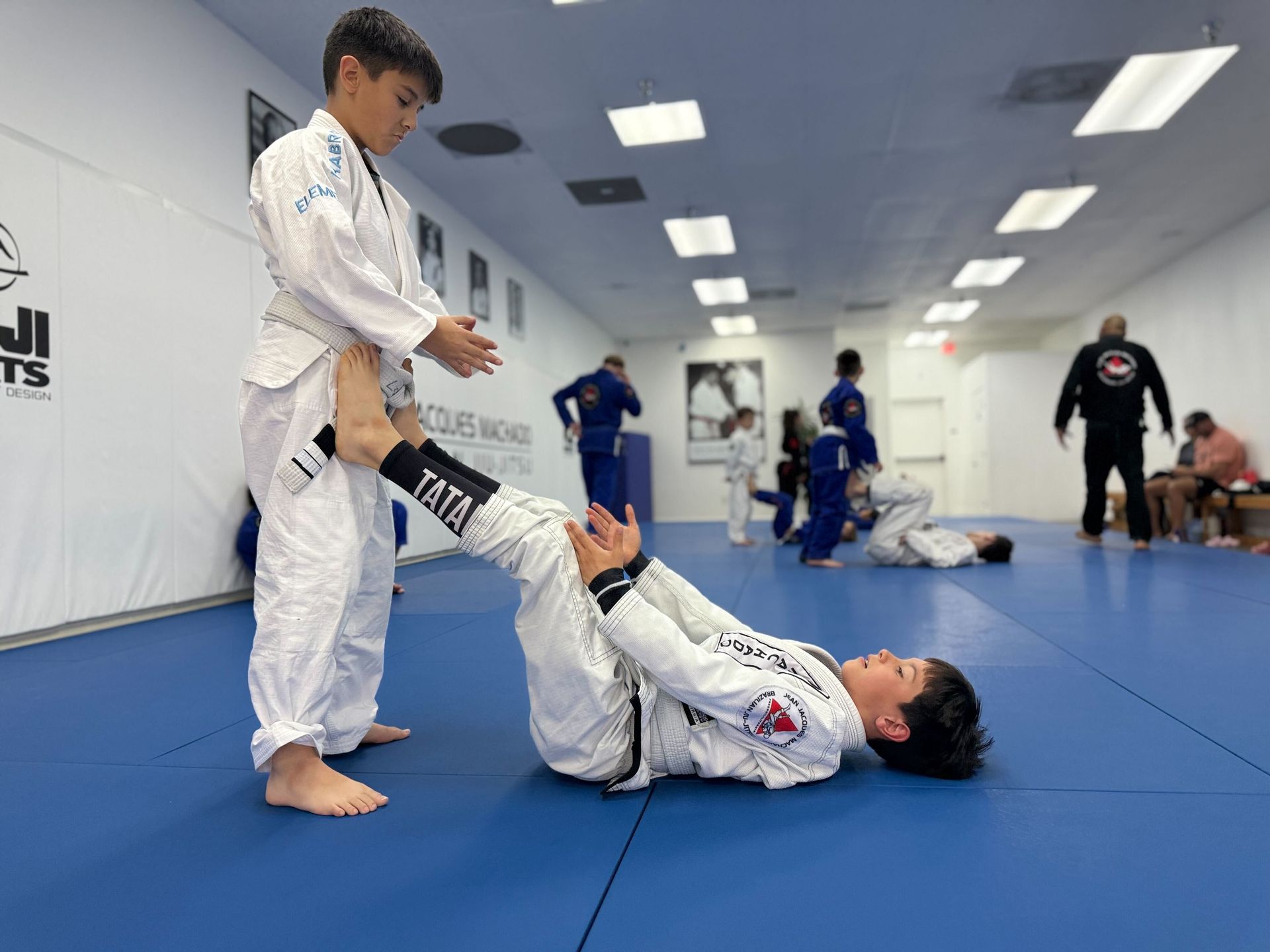 Adults and kids practicing Brazilian Jiu-Jitsu drills at Jean Jacques Machado Jiu-Jitsu Fresno in Fresno, CA for confidence.