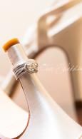 Close-up of a white dress form with a silver ring, softly lit in a warm indoor setting