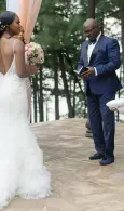 Bride and groom facing each other outdoors in wedding attire, with trees in the background.