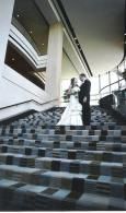 Bride and groom standing on a patterned staircase in a modern lobby