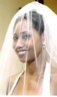 Smiling woman in a white veil, facing slightly left.