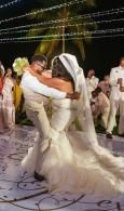 Bride and groom dancing at an outdoor wedding reception under string lights
